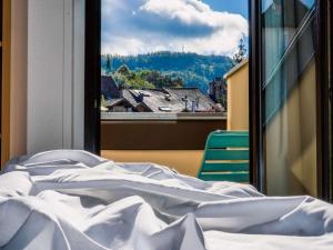 a bed and a window with a view of a city at ibis Annecy Centre Vieille Ville in Annecy