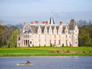 un hombre en un kayak en el agua frente a un castillo en ibis Nantes Centre Gare Sud en Nantes