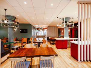 a restaurant with wooden tables and chairs and a table at ibis Styles Luxembourg Centre Gare in Luxembourg