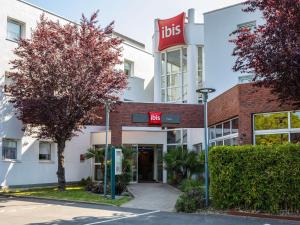 un hotel con letrero aubs frente a un edificio en ibis Massy, en Massy