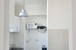 una cocina blanca con microondas en un estante en Alquiler temporario en Recoleta Palermo en Buenos Aires