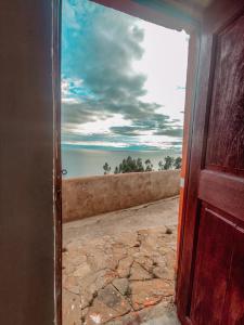 an open door with a view of the water at INTI WASI LODGE in Comunidad Yumani