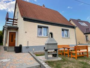 a house with two benches and a grill in front of it at Ferienhaus-Saale-Unstrut in Wethau