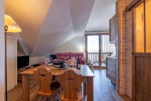 ein Esszimmer mit einem Tisch mit Weingläsern in der Unterkunft L'Ours des Alpages - 301C - Piscine partagée in Villarembert