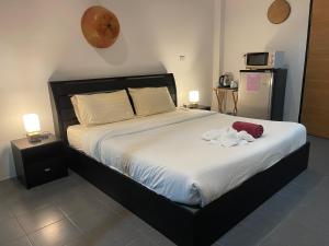 a bedroom with a bed with a stuffed animal on it at Lotus Bleu Resort & Restaurant in Rawai Beach