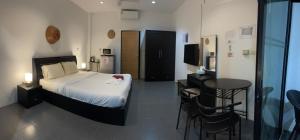 um quarto com uma cama, uma mesa e cadeiras em Lotus Bleu Resort & Restaurant em Praia de Rawai