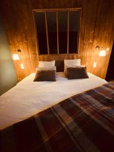 a bedroom with a large bed with two pillows at LA CABANE AFFRANCHIE in Moussy