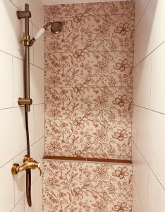a shower in a bathroom with a floral wallpaper at LA CABANE AFFRANCHIE in Moussy