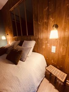 a bedroom with a bed in a wooden wall at LA CABANE AFFRANCHIE in Moussy