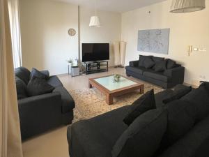 uma sala de estar com dois sofás e uma mesa de centro em CozyNest - 3br Beachfront apt, JBR em Dubai