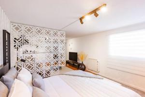een witte slaapkamer met een groot bed en een televisie bij Gaia Elegant Retreat I in Canidelo