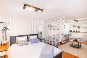 a bedroom with a large white bed and a kitchen at Gaia Elegant Retreat I in Canidelo