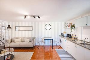 a kitchen and a living room with a couch at Gaia Elegant Retreat I in Canidelo