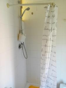a bathroom with a shower curtain with writing on it at Romiti Apartment in Ferrara