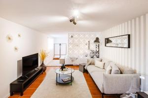 a living room with a couch and a tv at Gaia Elegant Retreat I in Canidelo