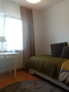 a bedroom with a bed and a window and a desk at Alte Remise im Herzen von Varel in Varel