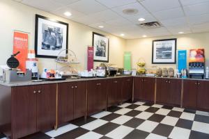 a restaurant with wooden cabinets and a checkered floor at Hampton Inn Cincinnati Airport South in Florence