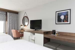 a hotel room with a bed and a desk with a television at Hampton Inn Cincinnati Airport South in Florence