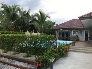 a house with a garden and a swimming pool at Pajaree and Udo‘s Happy Homestay in Trang