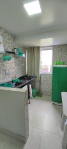 una cucina con piano cottura e armadietto verde di Guest House Renascer K&W a Cabo Frio