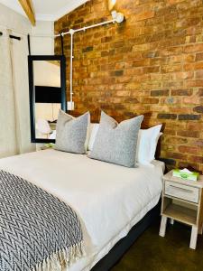 a bedroom with a large bed with a brick wall at Maboneng Haven 1 in Johannesburg