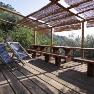 una terraza de madera con mesa de picnic y banco en Agririfugio Molini en Camogli