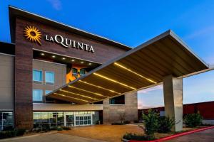 a building with a sun sign on top of it at La Quinta by Wyndham Houston Cypress in Cypress