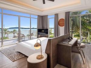 富國的住宿－Premier Village Phu Quoc Resort Managed by Accor，一间卧室设有一张床,阳台配有电视。