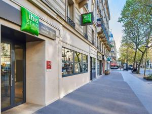 un bâtiment avec beaucoup de panneaux sur son côté dans l'établissement Ibis Styles Hotel Paris Gare de Lyon Bastille, à Paris