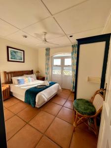 1 dormitorio con 1 cama y 1 silla en Caribbean Estates Montego Bay 38, en Port Edward
