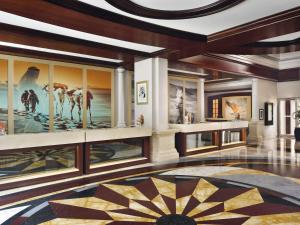 a lobby with a large painting on the wall at Mövenpick Hotel & Apartments Bur Dubai in Dubai