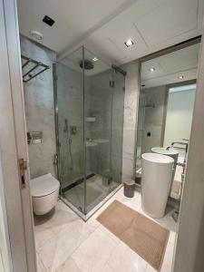 La salle de bains est pourvue d'une douche en verre et de toilettes. dans l'établissement Studio neuf confort bien placer, à Casablanca