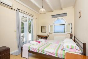 a bedroom with a bed and a window at Villa Mavrikia in Sfakerá