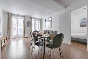 a dining room with a table and chairs and a bed at SD1 - Magnifique Appartement 2BR/6P - Center Paris in Paris