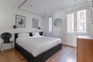 a white bedroom with a bed and a chair at SD1 - Magnifique Appartement 2BR/6P - Center Paris in Paris