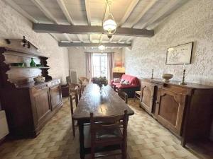 a dining room with a table and a living room at Chez michou ii in Horsarrieu