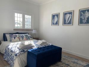 um quarto com uma cama com um repousa-pés azul em Haven House , Bom Sucesso Beach no Vau