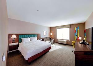 a large hotel room with a bed and a desk at Hampton Inn Needles in Needles