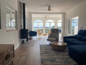 uma sala de estar com um sofá azul e uma mesa em Haven House , Bom Sucesso Beach no Vau