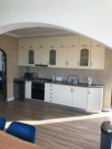 uma cozinha com armários brancos e electrodomésticos pretos em Haven House , Bom Sucesso Beach no Vau