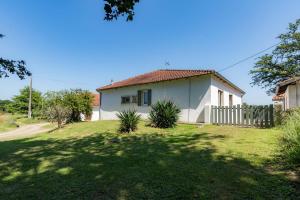 una casa blanca con una valla y un patio en Gite caperot, en Eyrès - Moncube