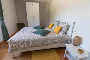 a bedroom with a white bed with colorful pillows at Gite caperot in Eyrès - Moncube +32 photos