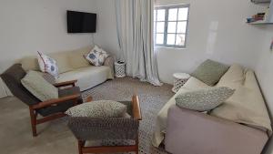 a living room with a couch and two chairs at The Beach Bungalows in Zinkwazi Beach