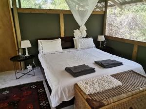 a bedroom with a large bed with two towels on it at The Tshilli Farm & Lodge in Maun