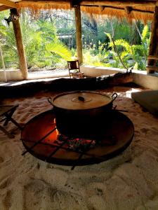a large pot on a stove in the sand at The Tshilli Farm & Lodge in Maun