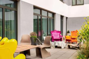 a patio with colorful chairs and a table at Amedia Dachau, Trademark Collection by Wyndham in Dachau