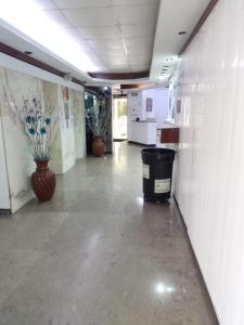 um corredor vazio num escritório com uma lata de lixo em HOTEL PARQUE VIA em Cidade do México