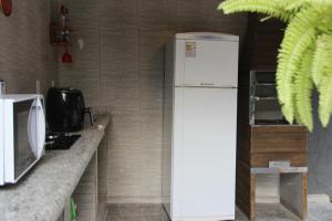 uma cozinha com um frigorífico e um micro-ondas em Casa Mãe da Lua em Arraial d'Ajuda