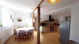 eine Küche und ein Esszimmer mit einem Tisch und Stühlen in der Unterkunft La Sarriette proche des plages du débarquement in Saint-Martin-des-Entrées