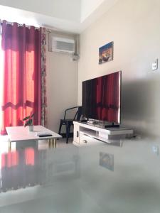 a living room with a flat screen tv and a table at 1BR Suite in Manhattan Heights Tower D in Manila